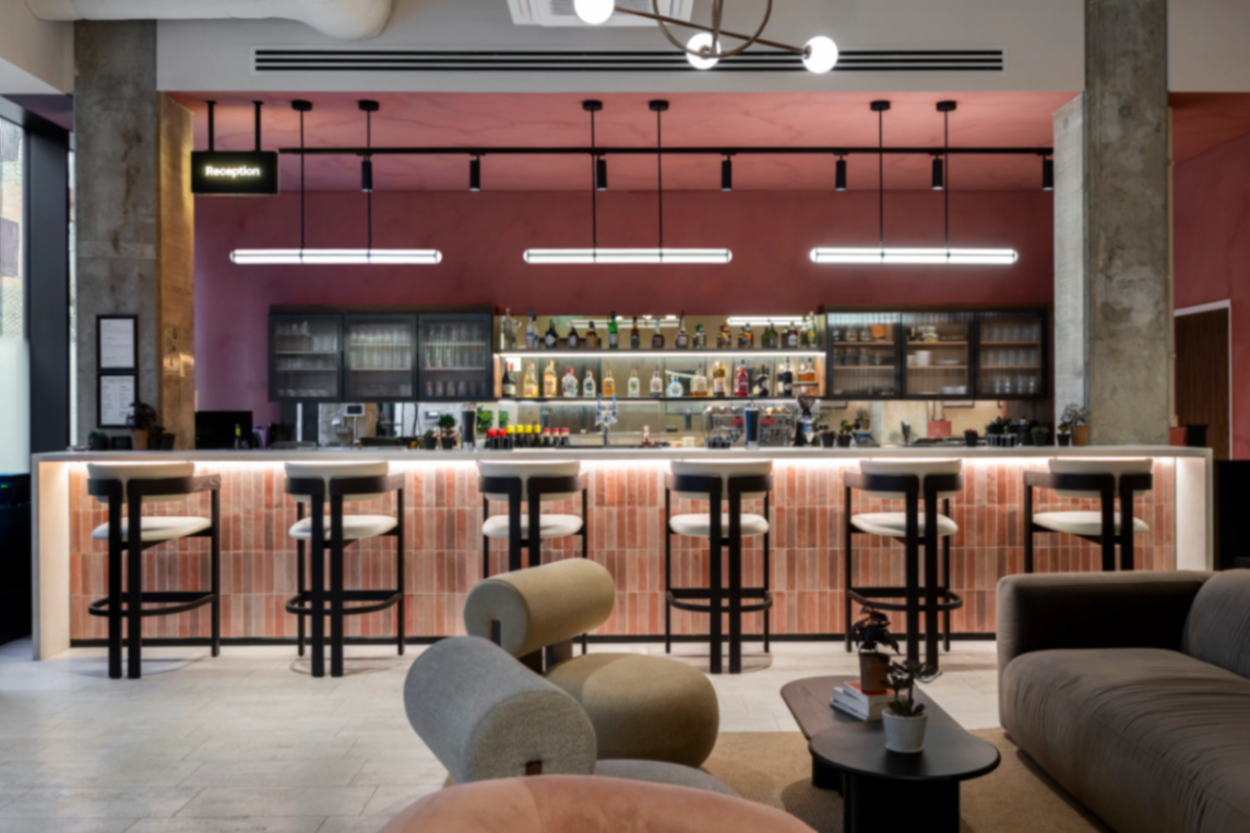 Bar interior with soft pink walls and stools